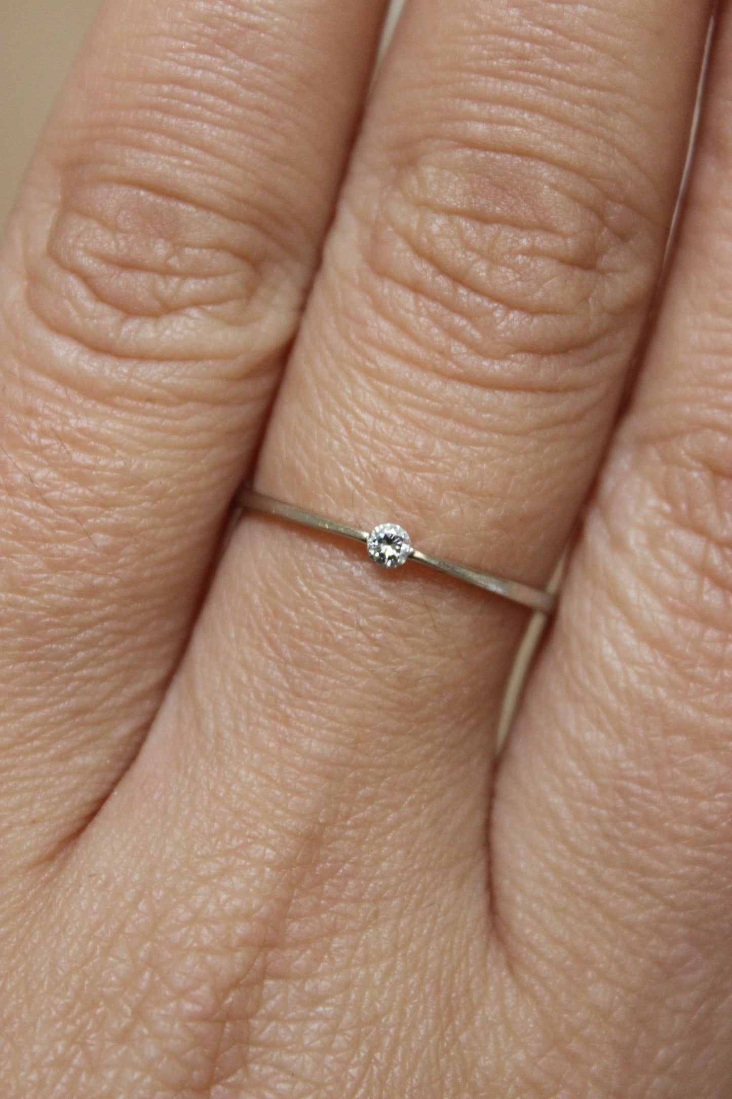 Minimalist 18K white gold solitaire ring with a small, sparkling diamond