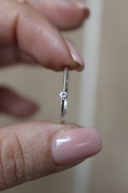 Minimalist 18K white gold solitaire ring with a small, sparkling diamond